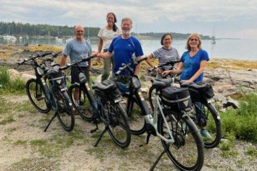 a group of people standing next to a bicycle